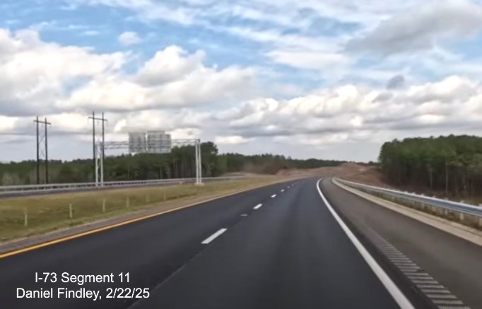 Screen grab image of newly opened I-73 North/I-74 West lanes passing overhead signage
heading south for US 74 West, Daniel Findley, February 2025