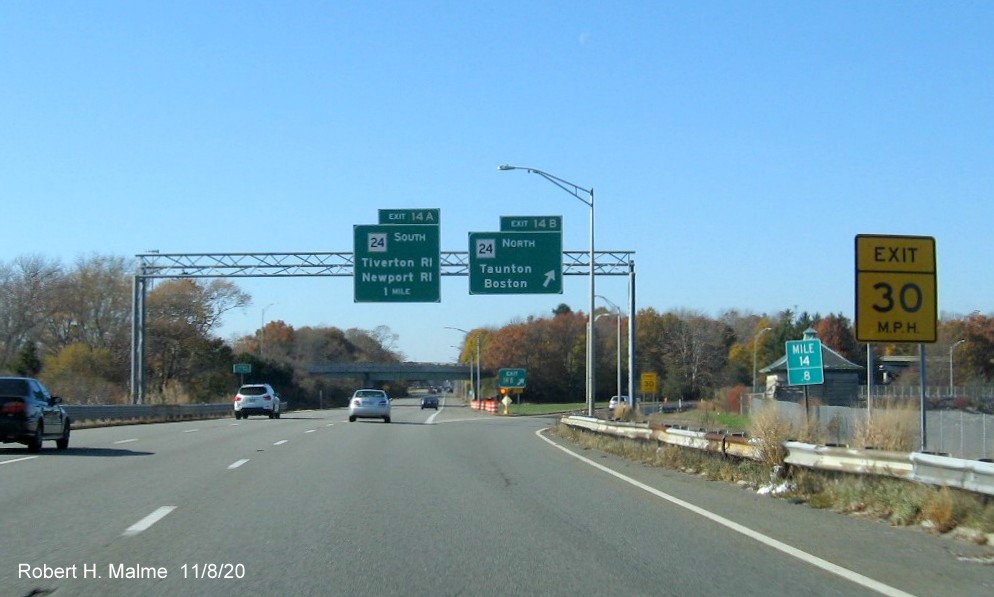 Image of overhead signage at exit ramp to MA 24 North with new milepost based exit numbers and gore sign with new number and yellow old exit number tab below on I-195 West in Fall River, November 2020