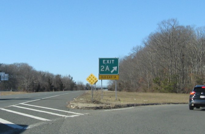 Image of gore sign US 1 South exit with new milepost based exit number and yellow Old Exit 1B sign below on I-295 South in North Attleborough, January 2021