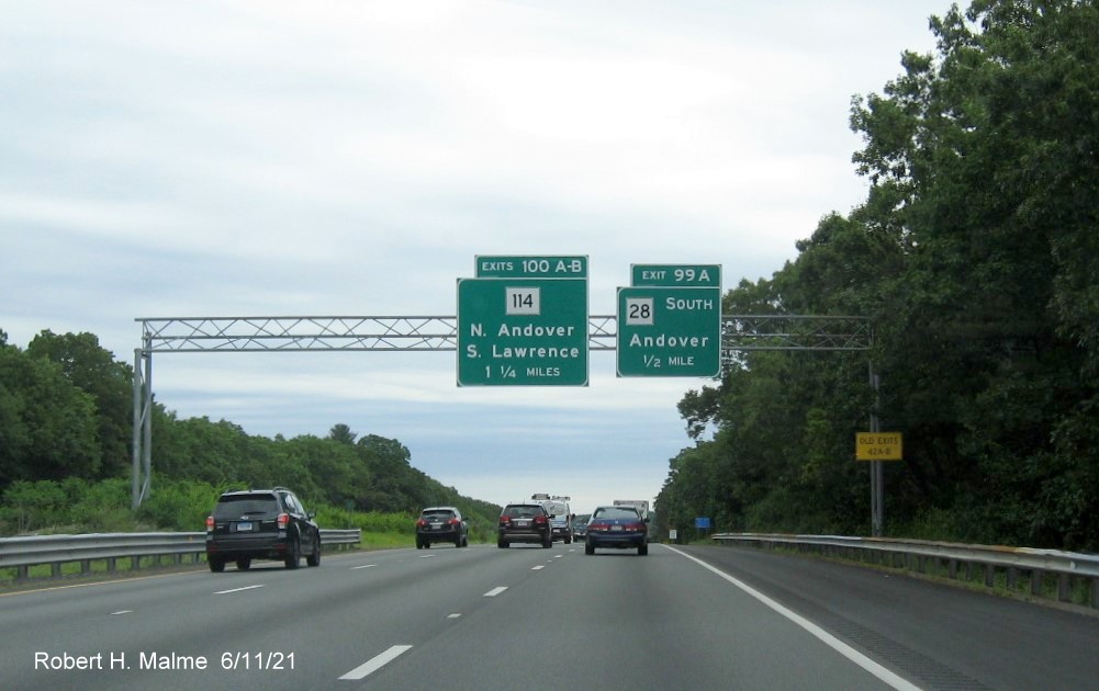 Image of 1 mile advance overhead sign for MA 114 exits with new first triple digit milepost based exit number and yellow Old Exits 42 A-B advisory sign on right support on I-495 North in Andover, June 2021
