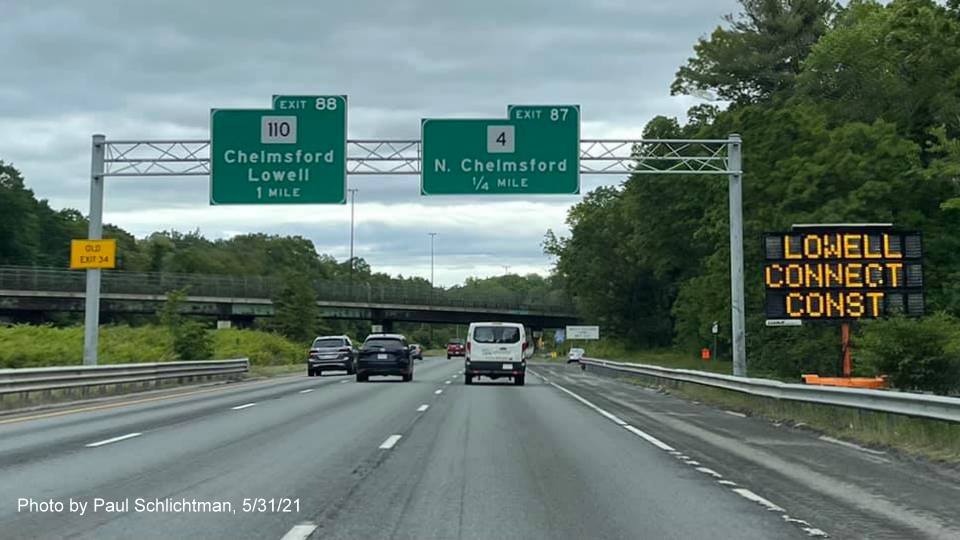 Image of advance signs for MA 110 and MA 4 exits with new milepost based exit numbers and yellow Old Exit 34 advisory sign on left support on I-495 North in Chelmsford, by Paul Schlichtman, May 2021
