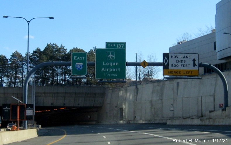 Image of 1 mile advance overhead sign for Logan Airport exit with new milepost based exit number on I-90/Mass Pike East in South Boston, January 2021