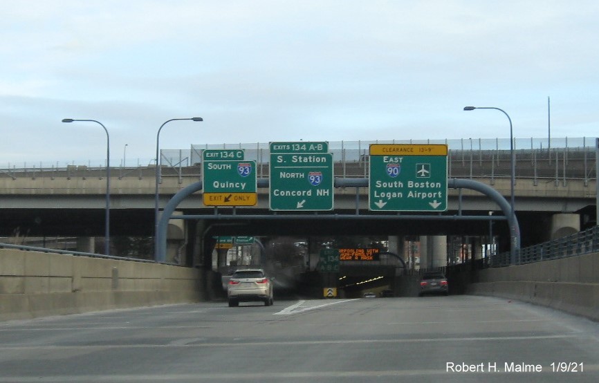 Image of overhead ramp signs for I-93 and South Station exits with new milepost based exit numbers on I-90/Mass Pike East in Boston, January 2021