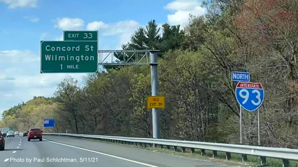 Image of 1 mile advance overhead sign for Concord Street exit with new milepost based exit number and yellow
                                           Old Exit 39 advisory sign on support on I-93 North in Wilmington, by Paul Schlichtman, May 2021
