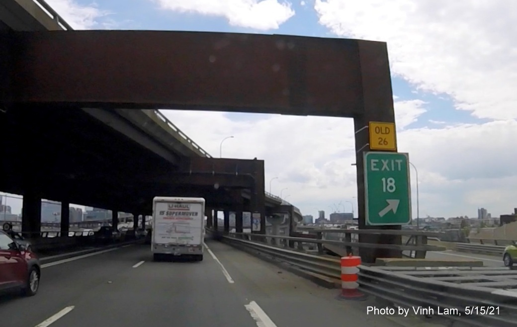 Image of gore sign for MA 28/MA 3/Storrow Drive exit with new milepost based exit number and yellow Old Exit 26 sign attached below on I-93 South in Somerville, by Vinh Lam, May 2021