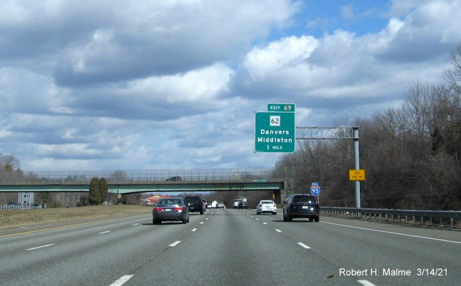 Image of 1 mile advance sign for MA 62 exit with new milepost based exit number and yellow old Exit 49 advisory sign on support on I-95 North in Danvers, March 2021