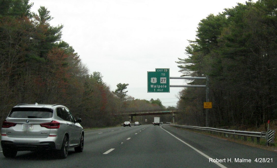 Image of 1 Mile advance overhead sign for US 1 to MA 27 exit with new milepost based exit number and yellow Old Exit 9 advisory sign on support on I-95 North in Walpole, April 2021