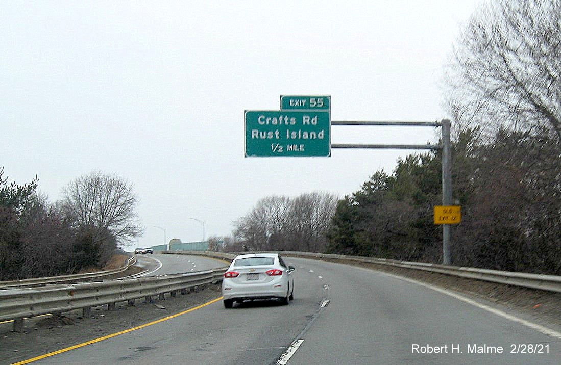 Image of 1/2 mile advance overhead sign for Crafts Road exit with new milepost based exit number and yellow old exit number sign on support post on MA 128 South in Gloucester, February 2021