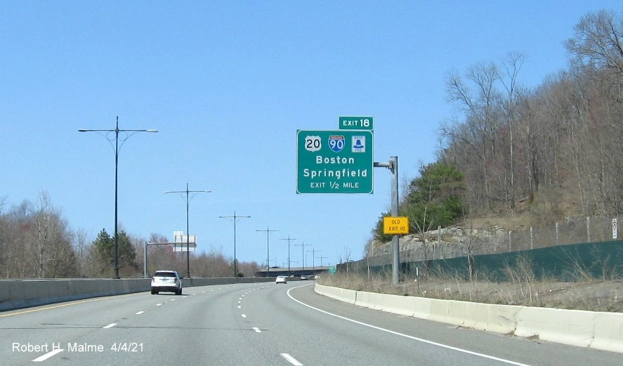 Image of 1/2 Mile advance overhead sign for I-90/Mass Pike exit with new milepost based exit number and yellow Old Exit 10 advisory sign on support on MA 146 North in Millbury, April 2021
