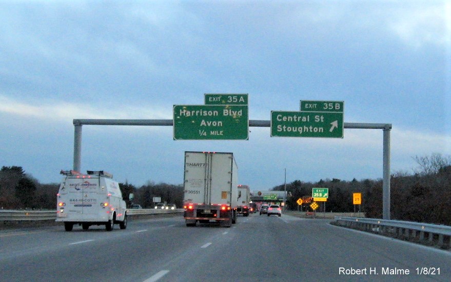 Image of overhead signs at ramp to Central Street exit with new milepost based exit number 
                                      and gore sign with new number and yellow old exit number sign below on MA 24 South in Avon, January 2021