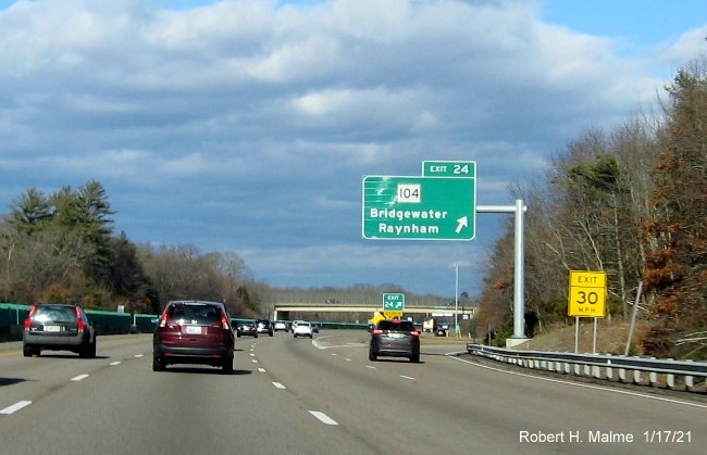 Image of overhead ramp sign for MA 104 exit with new milepost based exit number and gore sign with new number and yellow Old Exit 15 sign below on MA 24 North in Bridgewater, January 2021