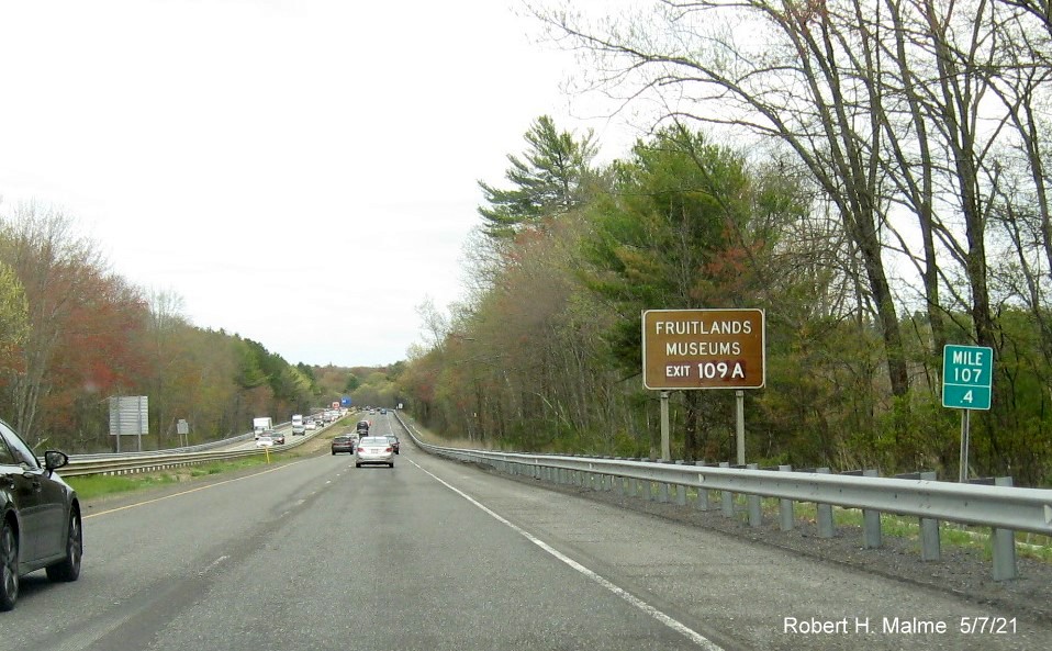 Image of auxiliary sign for MA 110/111 exits with new milepost based exit numbers and yellow Old Exits 38 A-B sign on support on MA 2 East in Harvard, May 2021