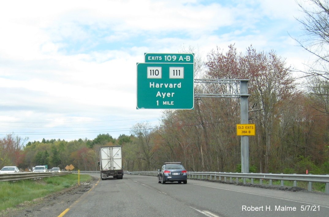 Image of 1 mile advance overhead sign for MA 110/111 exits with new milepost based exit numbers and yellow Old Exits 38 A-B sign on support on MA 2 East in Harvard, May 2021