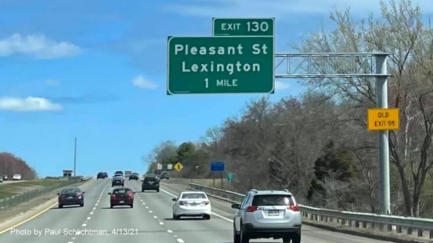 Image of 1 Mile advance overhead sign for Pleasant Street exit with new milepost based exit number and yellow Old Exit 55 advisory sign on support on MA 2 East in Lexington, by Paul Schlichtman, April 2021