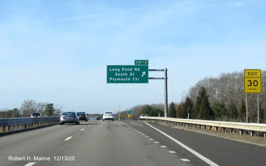 Image of overhead ramp sign for Long Pond Road exit with new milepost based exit number and gore sign with new number and yellow old exit number tab below on MA 3 North in Plymouth, December 2020