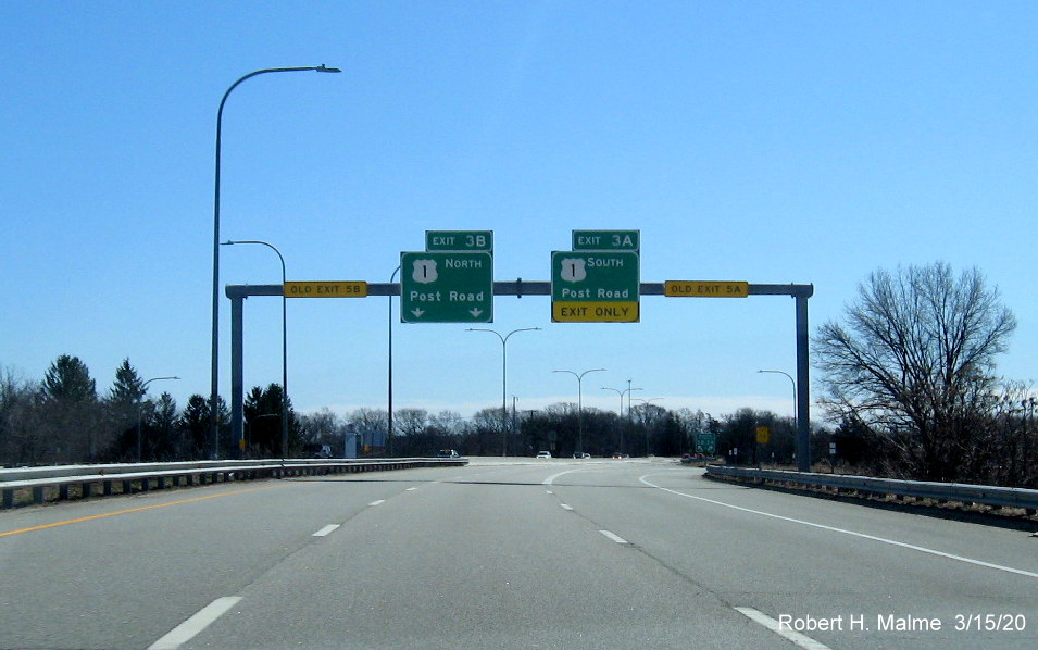 Image of overhead signage for US 1 exits at end of RI 37 East in Cranston featuring new exit numbers and old exit number tabs on horizontal support beam, taken in March 2020