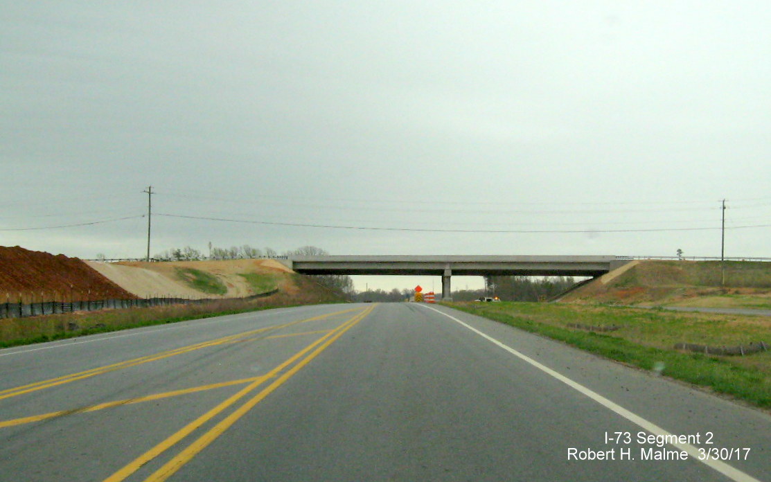 Image of view looking south along current US 220 roadway at nearly complete NC 65 bridge over the future interstate