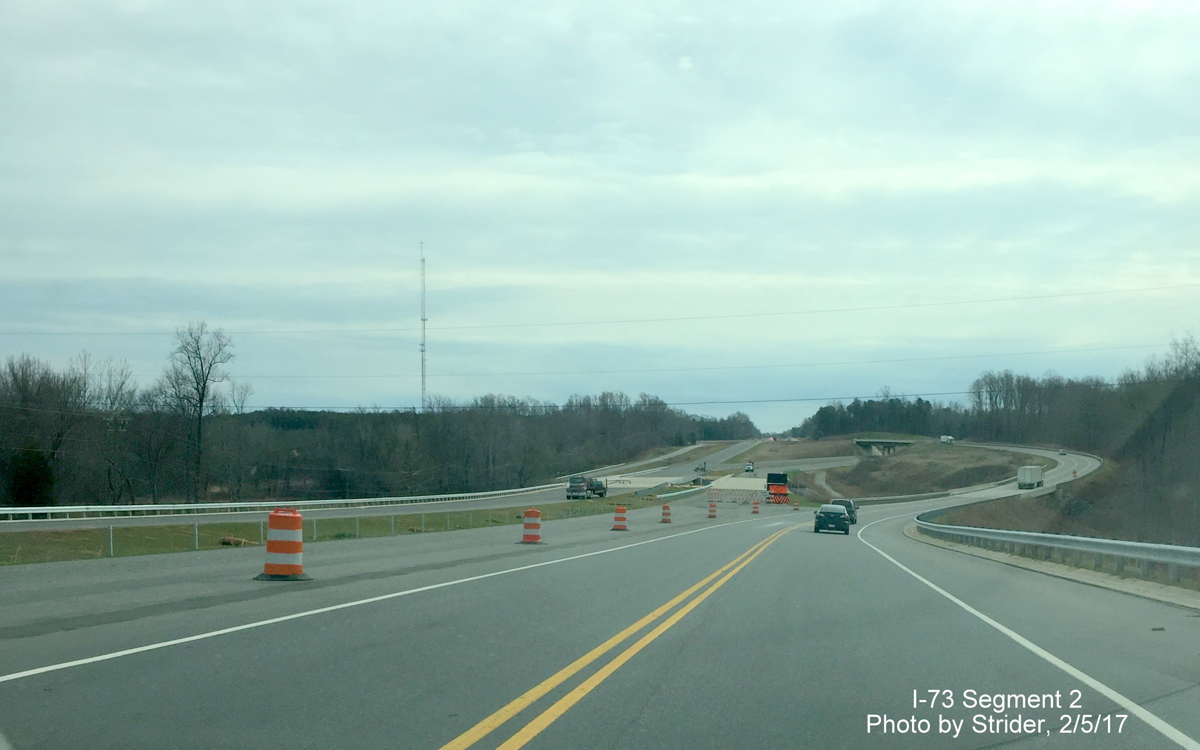 Image of view close to future I-73/US 220 interchange from US 220 South showing progress constructing guardrails.