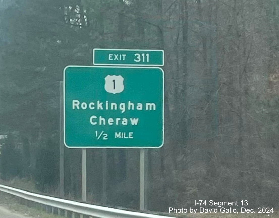 Image of new supports for a 1/2 mile advance sign for the US 1 exit going up 
	  behind the old sign on US 74 (Future I-74) East in Rockingham, by David Gallo, December 2024