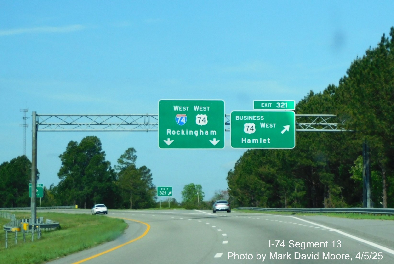 Image of overhead signs at the Business 74 exit at the beginning of the 
	  I-74/US 74 West Rockingham Bypass in Hamlet, Mark David Moore, April 2025