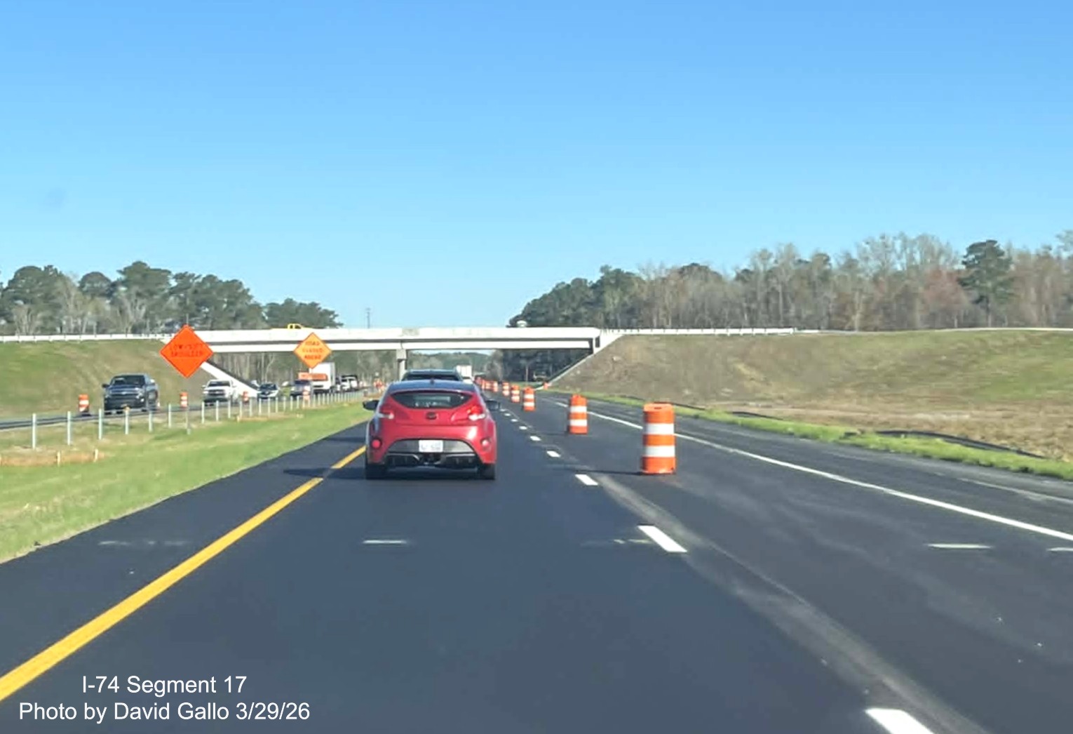 Image approaching the completed NC 72/ 130 West interchange bridge on US 74
(Future I-74) East in Robeson County showing traffic barrels still in place, by David Gallo, March 2026