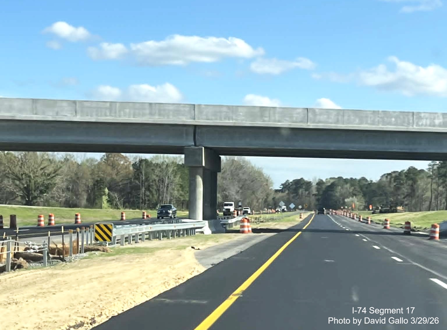Image at the completed NC 72/ 130 West interchange bridge on US 74
(Future I-74) East in Robeson County showing lane stripinc continuing along with traffic barrels, on the other side. By
David Gallo, March 2026