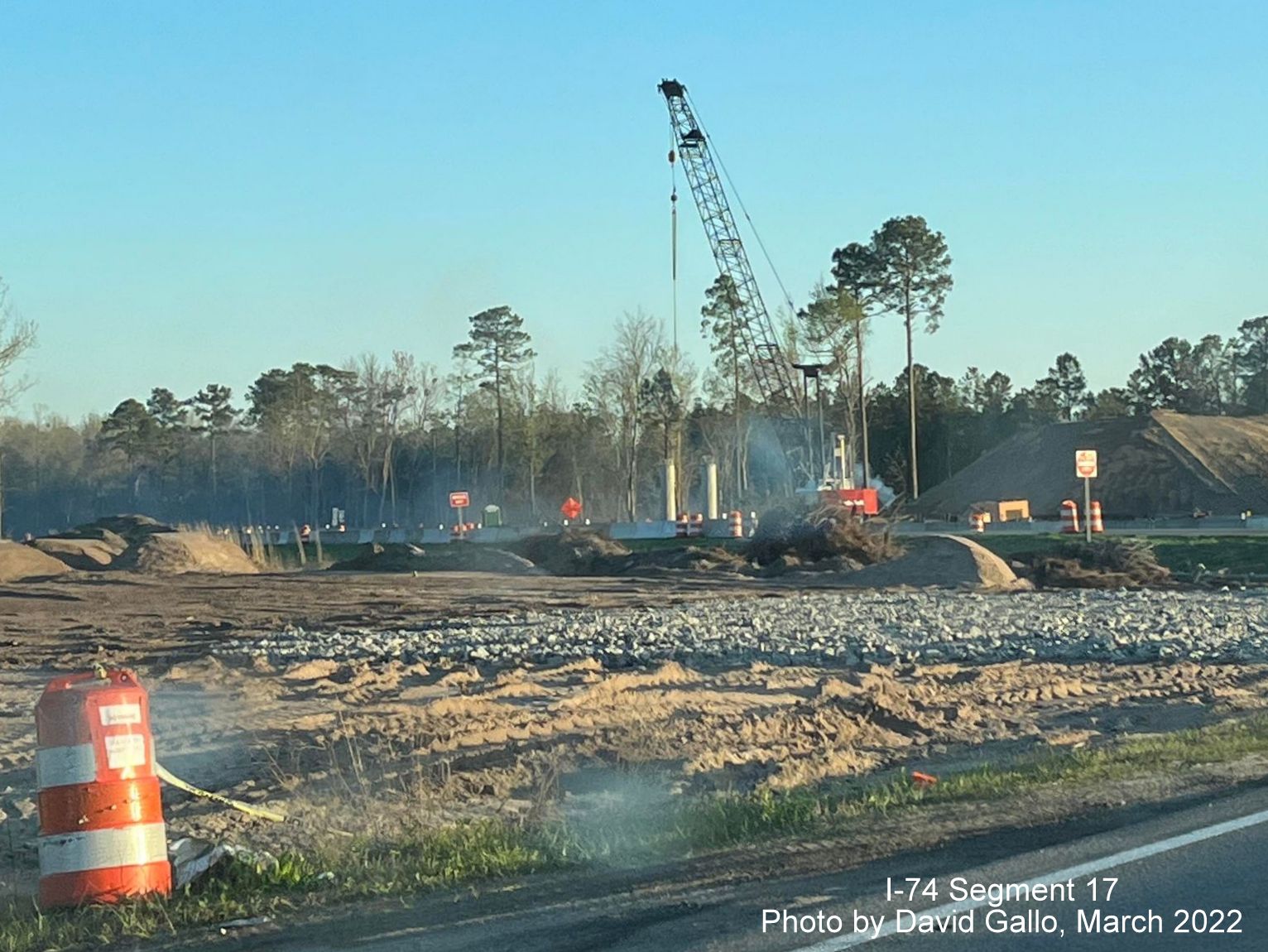 Image from Old Boardman Road of crane helping construct supports for future Boardman interchange bridge 
        on US 74 (Future I-74) West, by David Gallo, March 2022