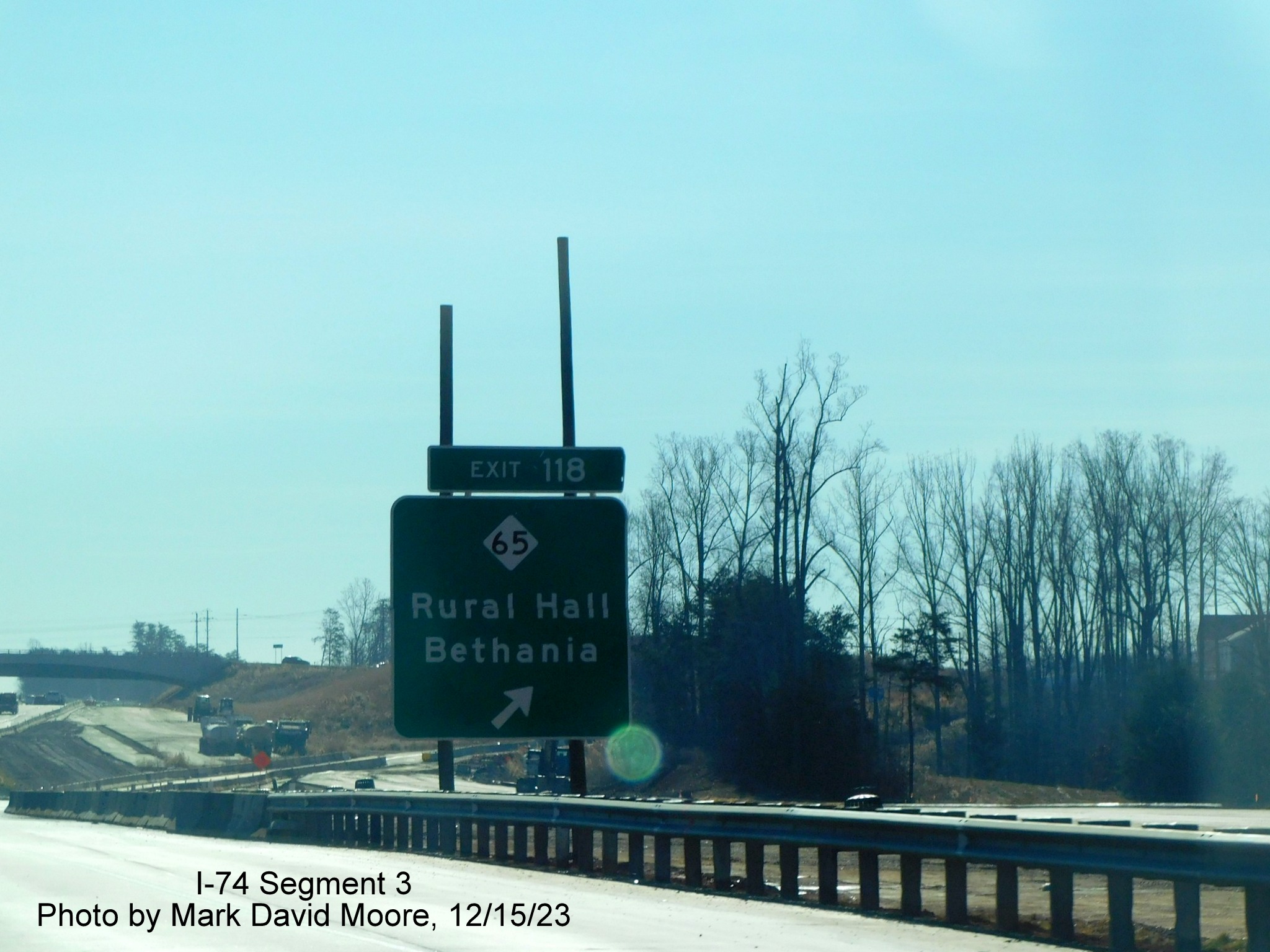 Image of ground mounted ramp sign for NC 65 exit on temporary eastbound lanes approaching the
        Winston-Salem Northern Beltway interchange in Rural Hall, by Mark David Moore, December 2023