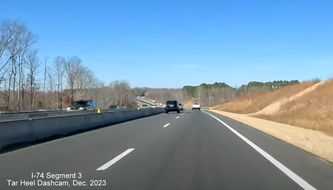 Image of driving completed lanes for US 52 North (Future I-74 West) approaching Westinghouse Road
        exit, left lane being used for US 52 South traffic, Tar Heel Dashcam, December 2023