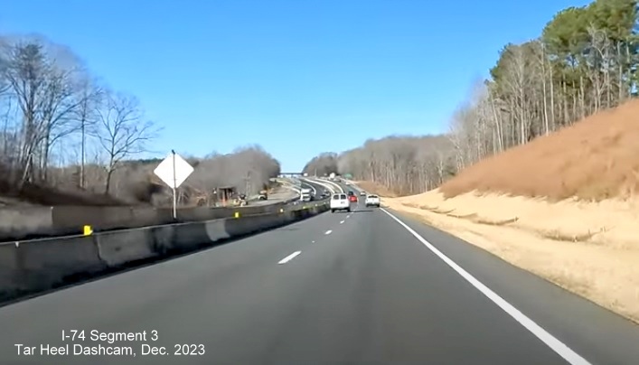 Image of driving completed lanes for US 52 North (Future I-74 West) approaching Westinghouse Road exit, 
        left lane being used for US 52 South traffic, Tar Heel Dashcam, December 2023