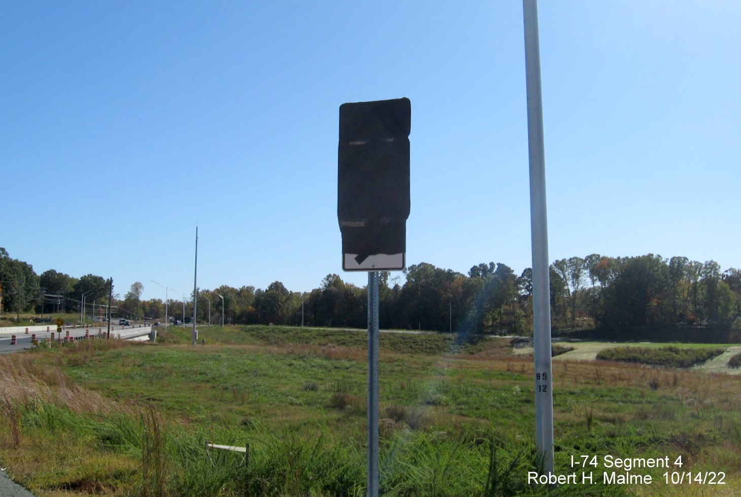 Image of covered over West NC 74 trailblazer heading south through roundabout on NC 8/Germanton Road north of the bridge across the Winston-Salem Northern
        Beltway, October 2022