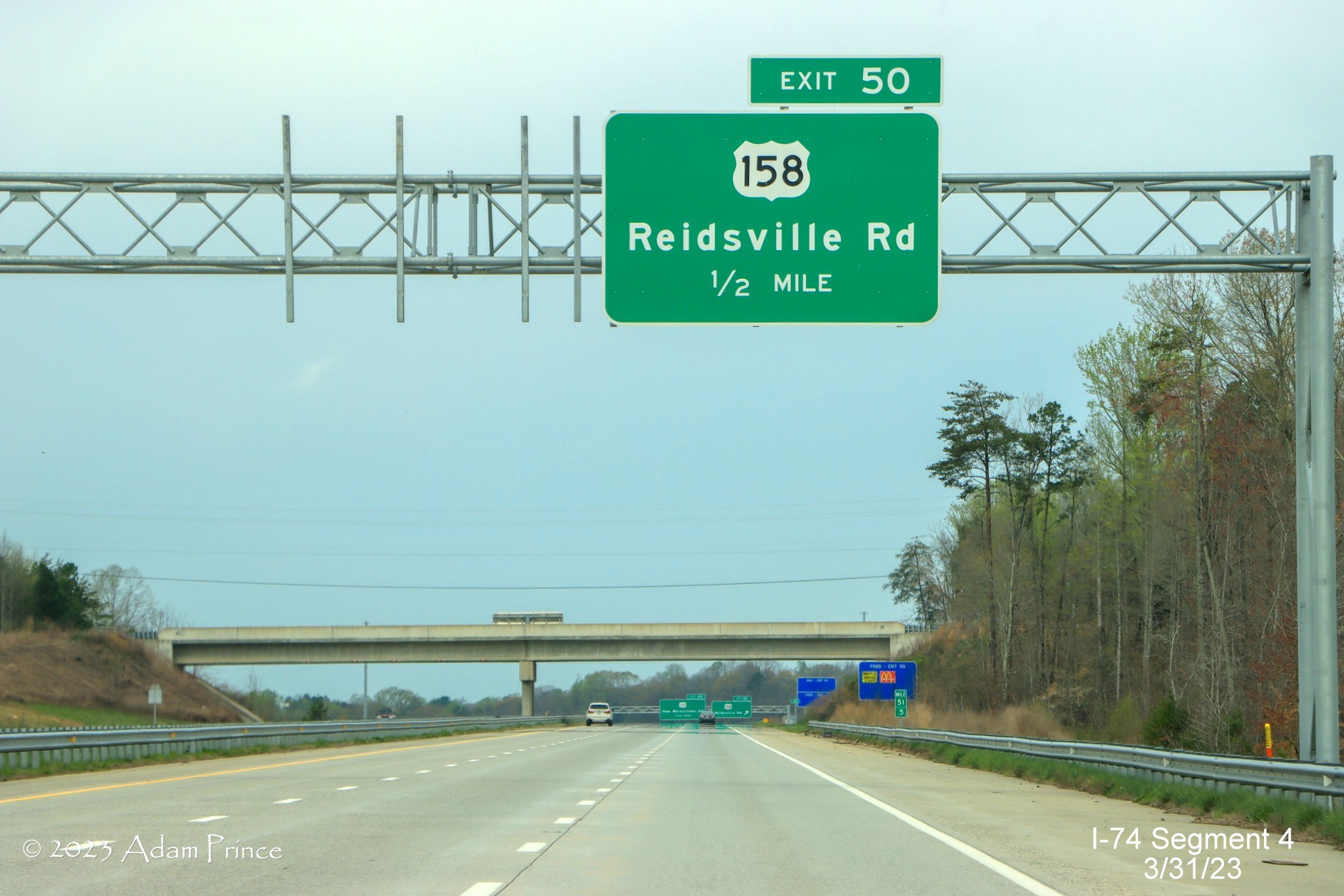Image of 1/2 mile advance overhead sign for the US 158 exit on NC 74 (Future I-74) West/Winston-Salem 
        Northern Beltway, Adam Prince, March 2023