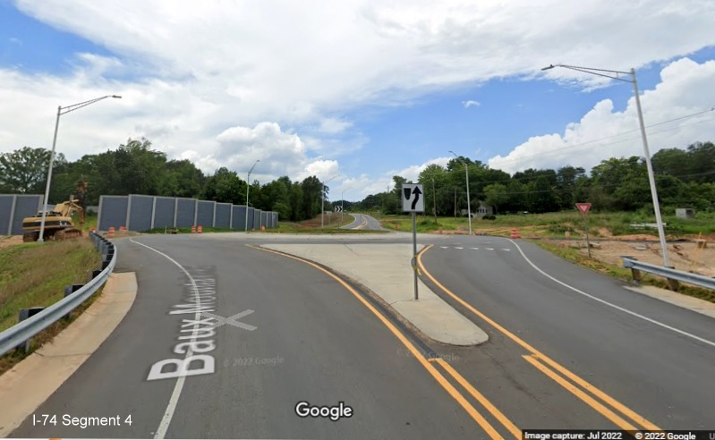 Image looking north toward second Baux Mountain Road roundabout containing future on and off-
          ramps to unopened Winston-Salem Northern Beltway / NC 74 (Future I-74) West, Google Maps Street View, July 2022