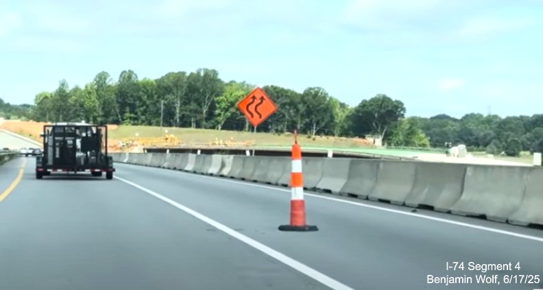 Image of advisory signage on I-74 West prior to a traffic shift to take the
	  lanes through the future NC 192 East off-ramp to the Winston-Salem Northern Beltway, screen grab from Benjamin Wolf video, 
	  June 2025