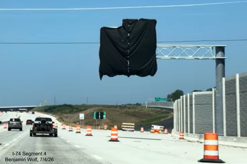 Image of covered up overhead ramp sign for the I-74/Beltway exit on I-40 West 
	 and gore sign beyond, screen grab from Benjamin Wolf video, July 4, 2026