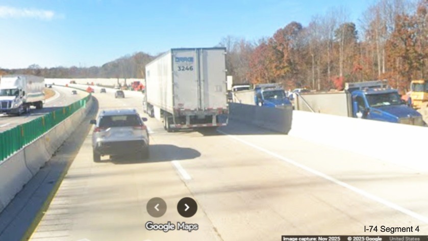 Image of current Future I-40 West lanes passing construction vehicles in future
permanent lanes building noise walls in I-74 Winston-Salem Northern Beltway interchange construction zone, Google
Maps Street View, November 2025