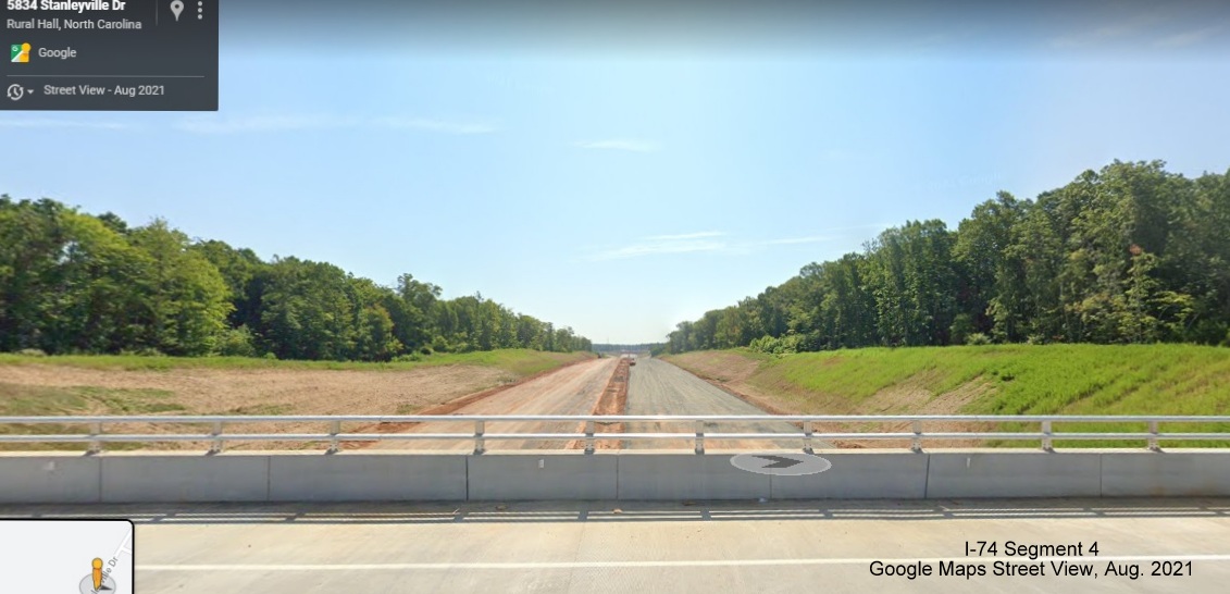 Image looking south from Stanleyville Drive bridge of future NC 74/Winston-Salem Northern Beltway roadbed partially paved, Google Maps Street View image, August 2021