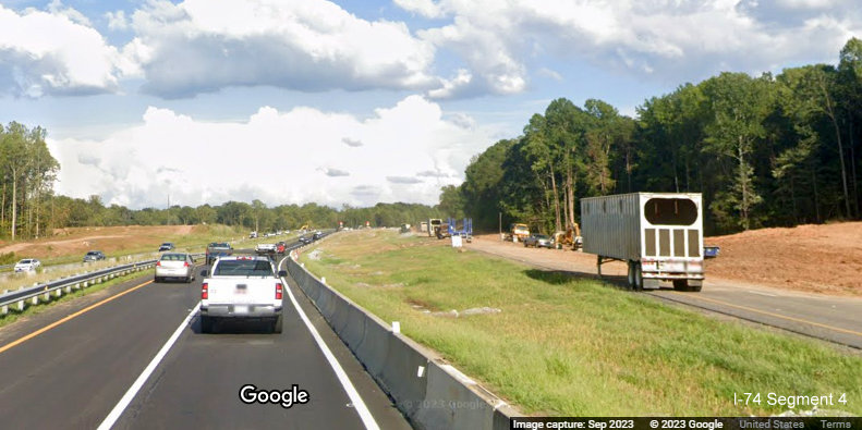 View of travelling in temporary I-74 East lanes through future Winston-Salem Northern Beltway 
       interchange construction, old I-74 lanes being used for equipment storage, Google Maps Street View, September 2023