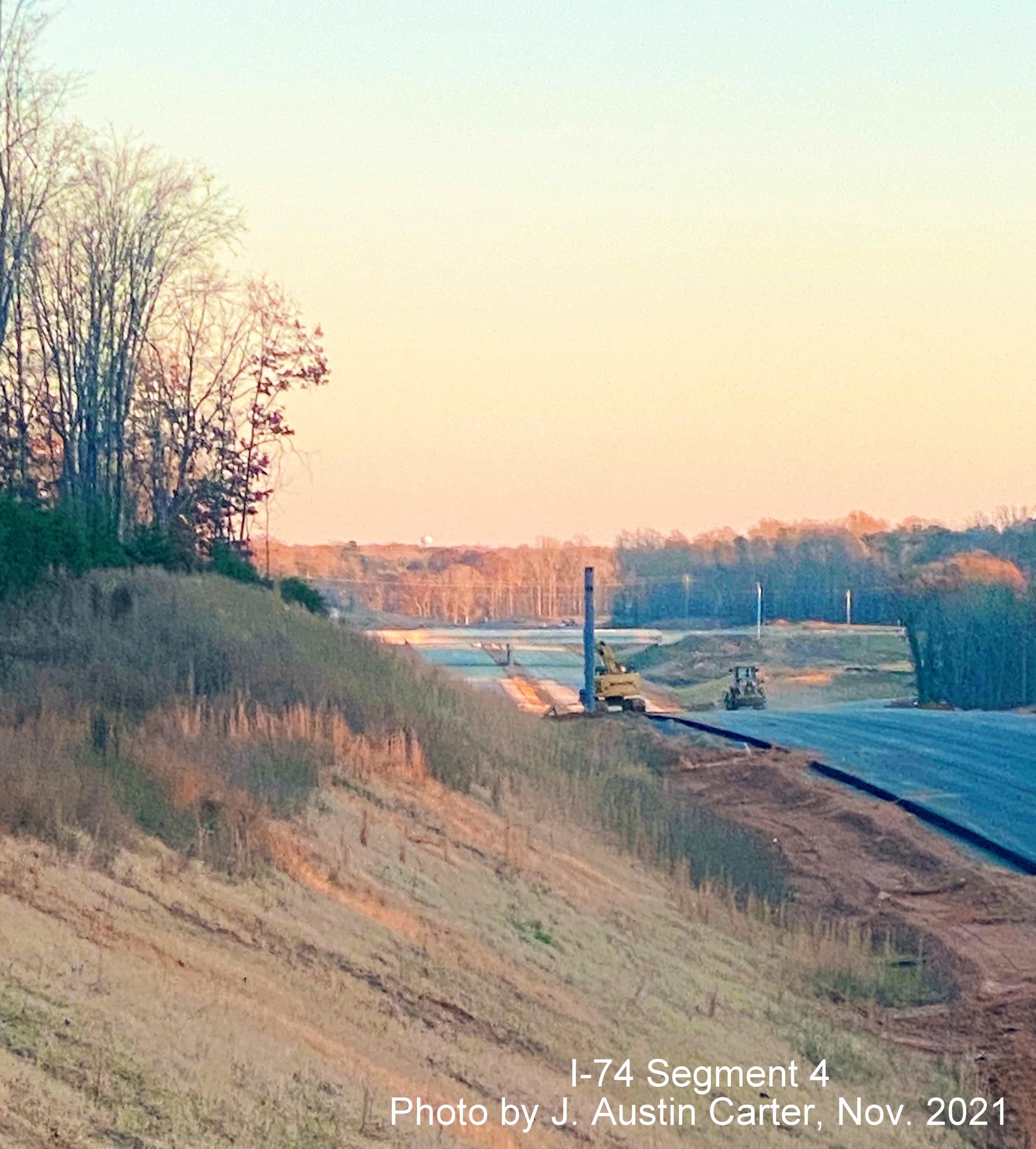 Image of closeup view looking southeast from near Stanleyville Drive showing construction of the I-74/Winston 
        Salem Northern Beltway toward the future NC 8/Germanton Road interchange showing installed overhead sign post, by J. Austin Carter, November 2021