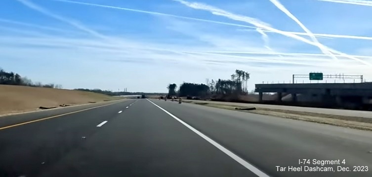 Image of NC 74 (Future I-74) East lanes using future westbound lanes after NC  65 bridge, from 
        video by Tar Heel Dashcam, December 2023