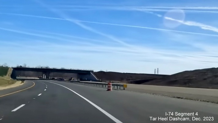 Image of NC 74 (Future I-74) East using future westbound lanes prior to future ramp bridge for
        US 52 South exit, from video by Tar Heel Dashcam, December 2023