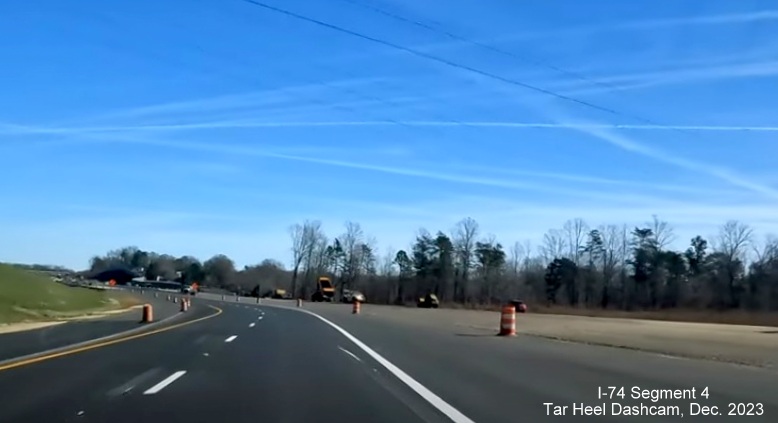 Image of NC 74 (Future I-74) East lanes using future westbound lanes approaching ramps being 
        contructed from US 52 North, from video by Tar Heel Dashcam, December 2023