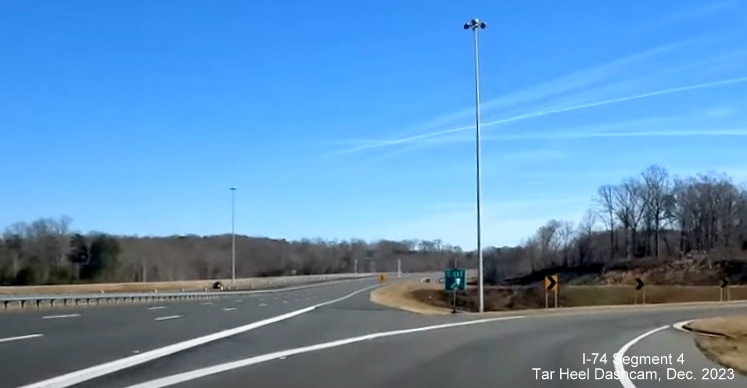Image of temporary gore sign still in place for NC 66/University Parkway exit on NC 74 (Future I-74)
        East after segment from US 52 South opened, from video by Tar Heel Dashcam, December 2023