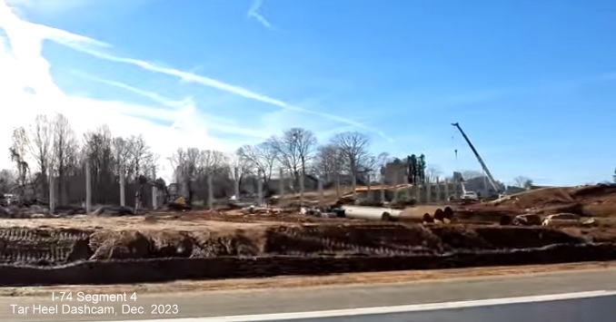 Image of noise wall construction along future ramp from I-74 West/Winston-Salem Northern
        Beltway exit to I-40 East, from video by Tar Heel Dashcam, December 2023