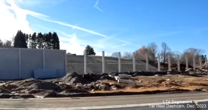 Image of noise wall construction at end of future ramp from I-74 West/Winston-Salem Northern
        Beltway exit to I-40 East, from video by Tar Heel Dashcam, December 2023
