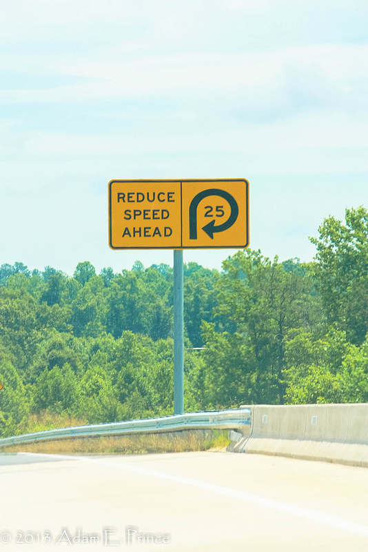 Photo of sign warning drivers to slow down on exit ramp from I-74 East to I-73 North near Randleman