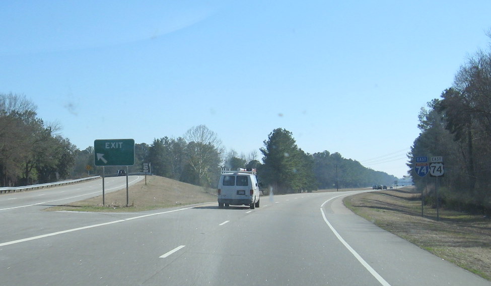 Photo of exit sign for US 74 Business with greened out duplicative exit 
number, Feb. 2009