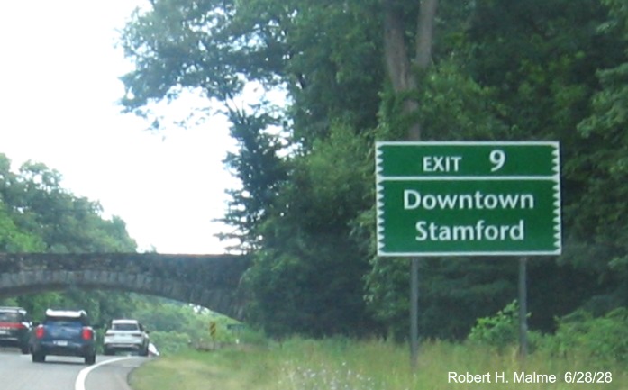Image of auxiliary sign for the Den Road exit, with new milepost based exit
 number on CT 15 North/Merritt Parkway in Greenwich