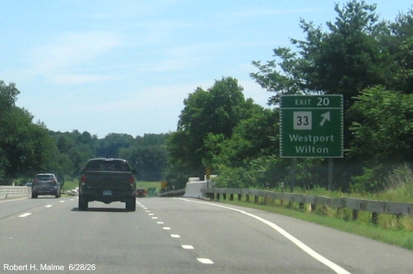 Image of the ground mounted exit sign for the CT 33 exit, with new 
 milepost based exit number on CT 15 North/Merritt Parkway in Westport, June 2026