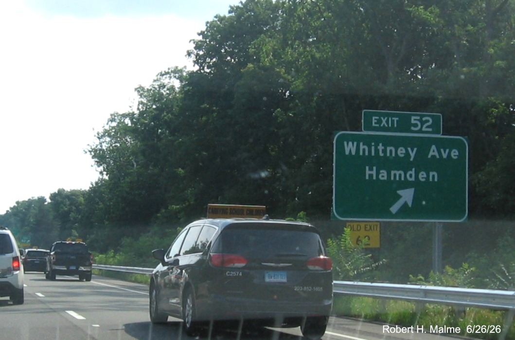 Image of ground mounted ramp sign for the first Whitney Avenue exit, with 
 new milepost based exit number with yellow Old Exit 62 sign on support post on CT 15 South/Cross Parkway in Hamden, 
 June 2026